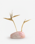 Decorative piece with gold birds of paradise on a pink quartz base against a white background