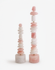 A pair of stacked pink and white quartz table top totem sculpture on a white background