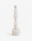 Stack of white quartz totem sculpture on a white background