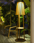 Wooden solar floor lamp and side table with pleated shade on a wooden deck at night by Les Jardins available at Spacio retail stores in Mumbai & Kolkata.