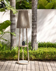 Tall outdoor floor lamp and side table with pleated design in a garden setting by Les Jardins available at Spacio retail stores in Mumbai & Kolkata.