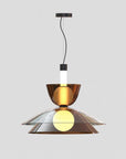 A modern pendant light fixture with a brushed bronze metal shade, a clear glass bowl, and a glowing warm yellow bulb inside, suspended by a black cord against a light gray background.