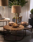 Round wooden coffee table with decorative items in a living room setting