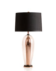 Table lamp with a black shade and copper base on a white background from Pieter Adam available at Spacio in India.