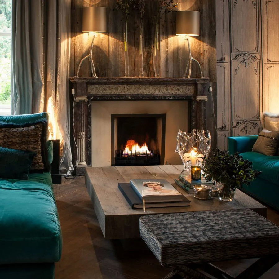 A living room with teal couches and a Planika Bioethanol Fireplace Hot Box.