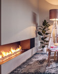 A modern living room with a Planika Fireplace Prime Fire and a yellow chair.