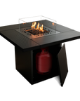 Black fire pit table with flames and a red propane tank on a white background