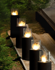 A row of black fireplace totem columns in an outdoor area