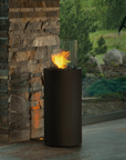 Portable indoor outdoor black column bioethanol fireplace from Planika in front of a brick stone column