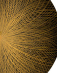 Close-up of a textured gold circular object with a starburst pattern on a black background