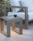 Outdoor setting with a weathered teak side table with solar light and a white sofa by Les Jardins available at Spacio retail stores in Mumbai & Kolkata.