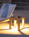 Outdoor setting with a lounge chair and small table illuminated by solar warm light by Les Jardins available at Spacio retail stores in Mumbai & Kolkata.