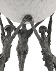 Bronze sculpture of three figures holding up a large sphere on a white background