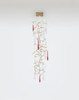 Decorative hanging wall lamp with gold branches and red accents on a white background