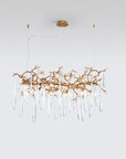 A Serip Aqua Chandelier, a nature-inspired gold chandelier with crystal drops hanging from it.