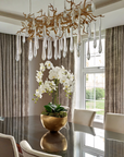 A dining room with a nature-inspired Serip Aqua Chandelier from Serip hanging over the table.