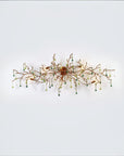 A wall light with Glass shaped falling droplets of water hanging from gold colour branches