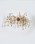 Side view of a wall light with Glass shaped falling droplets of water hanging from gold colour branches