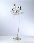 An ornate floor lamp with falling droplets shaped glass and small shades on a grey colour back ground.