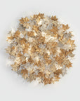 Decorative wall sculptural light with gold, silver, and bronze leaves on a light gray background from Serip's Folio collection, available at Spacio.