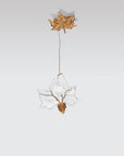 Decorative hanging light with a gold leaf and glass design on a light gray background