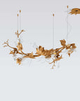 Decorative chandelier with gold leaf design on a light gray background from Serip available at Spacio