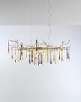 A chandelier hanging from the ceiling with colourful icicles shape glass on a light grey colour background