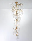 A double height chandelier in the shape of hanging stalactites on w white background.
