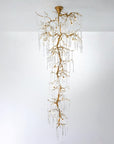 A double height chandelier in the shape of hanging stalactites on w white background.