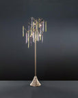A floor lamp with colourful glass icicles hanging from metal branches on a grey background