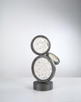 Decorative table lamp with circular design on a white surface and gray background