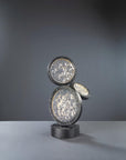 Decorative black finish table lamp with circular design on a gray background