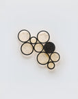 Set of black and gold circular earrings shaped wall light on a light gray background