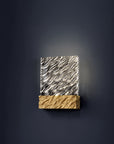 Decorative wall sconce with wavy design on a dark background