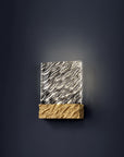 Decorative wall sconce with wavy design on a dark background