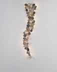 Decorative wall light with leaf-like design on a plain wall
