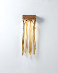 Decorative wall light fixture with gold finish on a white background