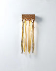 Decorative wall light fixture with gold finish on a white background
