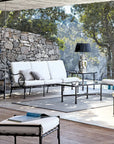 Distant view of Sifas Cross collection of three Sofa seating with a chair, center table & outdoor decorative table lamps at exterior available at Spacio India for luxury home Outdoor Furniture decor collection