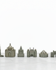 A set of six miniature Indian architectural models representing famous world landmarks, including the Taj Mahal, Mysore Palace, Qutab Minar , shown in a uniform matte gray-green color on a white marble surface against a white background.