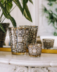 A set of Baobab Arabian Nights Candle MAX16ARN scented candles on a table next to a potted plant.