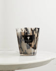 A Baobab Black Pearls Candle Max 16 MAX16PB, placed for decoration on a marble table.
