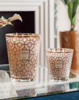 A Baobab Women Candle MAX16WOM is sitting on a table next to a vase, symbolizing support for the Breast Cancer Foundation and empowering women.