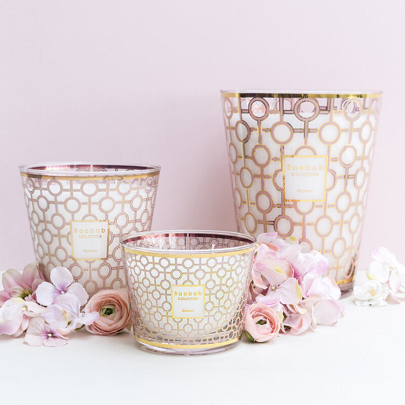 Three Baobab Women Candle Max 10 MAX10WOM candle holders with pink flowers on them, perfect for women who enjoy scented candles. Additionally, a percentage of the purchase will be donated to breast cancer research.