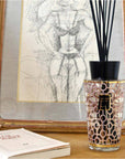 A Baobab Women Diffuser 500ml DIF500WOM sitting on a table next to a book, delighting women with its pleasant aroma.