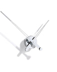 A Nomon wall clock with an avant-garde design featuring two swords: the Clock Nomon Axioma i 60 AXI.