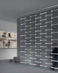 A man walks through a room with an Italamp Piola lighting fixture made of cast glass bars.