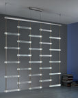 A room with a Italamp Piola lighting fixture hanging from the ceiling, featuring Italamp and cast glass bars.