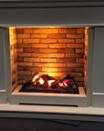 White fireplace mantle with a brick insert and glowing fire from artificial water vapour fireplace