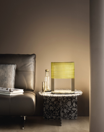 A living room with a brown couch and a yellow lamp featuring a stunning Masiero Ebe Table Lamp design.